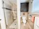 Well-lit bathroom featuring a glass-enclosed shower and a convenient toilet area with cabinet at 708 32Nd W St, Bradenton, FL 34205