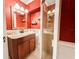 Red-walled bathroom featuring a granite vanity and a glass shower at 708 32Nd W St, Bradenton, FL 34205