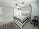 Cozy bedroom with floral wallpaper, a queen-sized bed, ceiling fan, and ample natural light at 708 32Nd W St, Bradenton, FL 34205