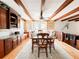 A dining room featuring exposed beams, a traditional table set, and adjacent built-in cabinets and shelving at 708 32Nd W St, Bradenton, FL 34205