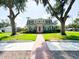 Charming two-story home with a well-maintained lawn and landscaped front yard and a brick walkway leading up to the front door at 708 32Nd W St, Bradenton, FL 34205