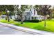 Well-maintained property with mature trees, lush green lawn, and a charming two-story home at 708 32Nd W St, Bradenton, FL 34205