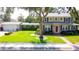 Charming two-story home featuring a red front door, lush landscaping, and a detached garage with breezeway at 708 32Nd W St, Bradenton, FL 34205