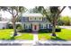 Stunning two-story home with red door, blue shutters, a brick walkway and beautiful curb appeal at 708 32Nd W St, Bradenton, FL 34205