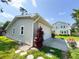 Detached garage with a white door, situated beside a house and a vibrant red plant at 708 32Nd W St, Bradenton, FL 34205
