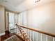 View of the upstairs hallway showcasing hardwood floors, stairs, and the entryway to a bathroom at 708 32Nd W St, Bradenton, FL 34205