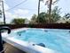 Relaxing hot tub surrounded by a wooden deck and privacy fence with lush greenery at 708 32Nd W St, Bradenton, FL 34205