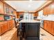 An open-concept kitchen with a large island, granite countertops, wood cabinets, and stainless steel appliances at 708 32Nd W St, Bradenton, FL 34205