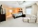 Spacious primary bedroom with neutral carpet, ceiling fans, sitting area, and ensuite bathroom access at 708 32Nd W St, Bradenton, FL 34205