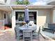 Covered outdoor kitchen boasts stainless steel grill and sink paired with a patio table for dining at 708 32Nd W St, Bradenton, FL 34205