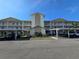 Condo exterior with a white facade, balconies, covered parking, and a well-maintained landscape at 7201 29Th Avenue W Dr # 306, Bradenton, FL 34209