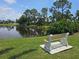 Picturesque pond view from a bench surrounded by lush greenery offers a peaceful retreat at 7201 29Th Avenue W Dr # 306, Bradenton, FL 34209