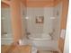 A bathroom has a white jacuzzi tub surrounded by light peach colored walls and tile at 7732 N Mobley Rd, Odessa, FL 33556