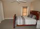 A bedroom with a brown bed frame, gray bedding, and a small side table at 7732 N Mobley Rd, Odessa, FL 33556