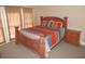 A bedroom with a wooden bed frame and an ornately designed headboard with a window at 7732 N Mobley Rd, Odessa, FL 33556