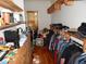 A cluttered walk-in closet with wood flooring is filled with hanging and stacked clothes at 7732 N Mobley Rd, Odessa, FL 33556
