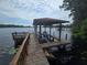 Boat dock featuring a covered lift with dual jet skis on a sunny day at 7732 N Mobley Rd, Odessa, FL 33556