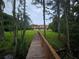 Waterfront home with a wooden boardwalk through the trees leading to the property at 7732 N Mobley Rd, Odessa, FL 33556