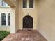 Arched front door is framed by brick patio, and windows in this elegant property at 7732 N Mobley Rd, Odessa, FL 33556