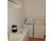 View of a laundry room with a washer, dryer, and folding counter at 7732 N Mobley Rd, Odessa, FL 33556