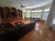Spacious living room with hardwood floors, built-in shelving, and natural light from large windows at 7732 N Mobley Rd, Odessa, FL 33556