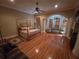 Large main bedroom with hardwood floors, ceiling fan, and sitting area at 7732 N Mobley Rd, Odessa, FL 33556