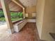 A covered outdoor kitchen area featuring a built-in sink, cabinets, and brick flooring at 7732 N Mobley Rd, Odessa, FL 33556