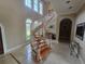 Curved staircase with wood steps, white risers, and lots of natural light from the arched windows at 7732 N Mobley Rd, Odessa, FL 33556
