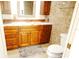 Bathroom vanity with wood cabinets, a marble countertop, and decorative mirror at 802 Capri Isles Blvd # 231, Venice, FL 34292