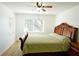 Bright bedroom with natural light, ceiling fan, wood floors, and a large bed at 802 Capri Isles Blvd # 231, Venice, FL 34292