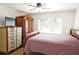 Bedroom with wood floors, ceiling fan, and dresser at 802 Capri Isles Blvd # 231, Venice, FL 34292