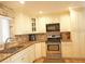 Kitchen area with stainless steel oven and range, microwave, granite counters and backsplash at 802 Capri Isles Blvd # 231, Venice, FL 34292