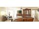 Living room area with a full wall dresser and shelves with a large screen television at 802 Capri Isles Blvd # 231, Venice, FL 34292