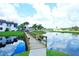 Scenic view of a community pond, foot bridge, and nearby house, illustrating the tranquil community setting at 802 Capri Isles Blvd # 231, Venice, FL 34292