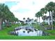 A picturesque view of a community pond with a fountain, lined with palm trees at 802 Capri Isles Blvd # 231, Venice, FL 34292