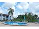 Community pool with lounge chairs, tables, and landscaping at 802 Capri Isles Blvd # 231, Venice, FL 34292
