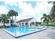 Beautiful community pool with a covered area, lounge chairs, and palm trees at 802 Capri Isles Blvd # 231, Venice, FL 34292