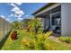 Landscaped backyard with lush lawn, potted plants, and a screened-in lanai at 8541 Whispering St, Sarasota, FL 34240