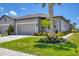 Well-maintained home exterior featuring a gray facade, a garage, and lush landscaping at 8541 Whispering St, Sarasota, FL 34240