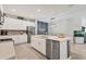 Spacious kitchen featuring white cabinets, stainless steel appliances and a large island with sink at 8541 Whispering St, Sarasota, FL 34240