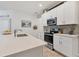 Bright kitchen featuring white cabinetry, stainless steel appliances, and a stylish backsplash at 8541 Whispering St, Sarasota, FL 34240