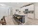 Bright kitchen with white cabinets, gray island with seating, stainless steel appliances, and stylish backsplash at 8541 Whispering St, Sarasota, FL 34240