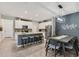 Open-concept kitchen with island seating, white cabinets, stainless appliances and adjacent dining area at 8541 Whispering St, Sarasota, FL 34240