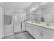 Bright main bathroom featuring double vanity sinks, a glass-enclosed shower, and modern fixtures at 8541 Whispering St, Sarasota, FL 34240