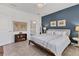 Spacious main bedroom with a large bed, blue accent wall, and ensuite bathroom entrance at 8541 Whispering St, Sarasota, FL 34240