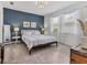 Cozy main bedroom with a large bed, blue accent wall, bedside tables, and ample natural light at 8541 Whispering St, Sarasota, FL 34240