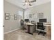 Spacious home office featuring tile floors, ceiling fan, dual desks, and natural light at 8541 Whispering St, Sarasota, FL 34240