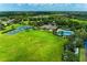 Wide aerial perspective of community amenities including tennis courts, swimming pool, and clubhouse set in lush greenery at 10708 52Nd E Ct, Parrish, FL 34219