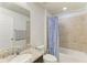 Bathroom features granite counters, a framed mirror, and a shower and tub combo behind a blue shower curtain at 10708 52Nd E Ct, Parrish, FL 34219