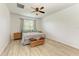 Bright bedroom with neutral colors, wood floors, ceiling fan, and window with blinds at 10708 52Nd E Ct, Parrish, FL 34219